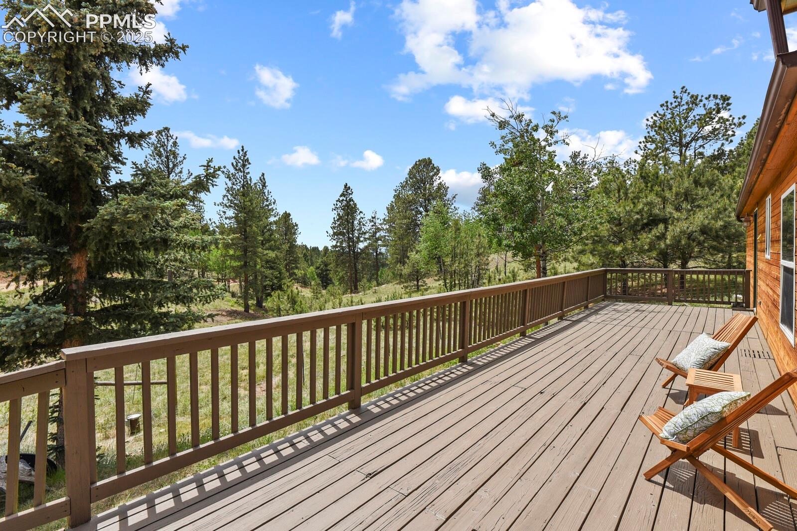 Wooden deck with view of wooded area
