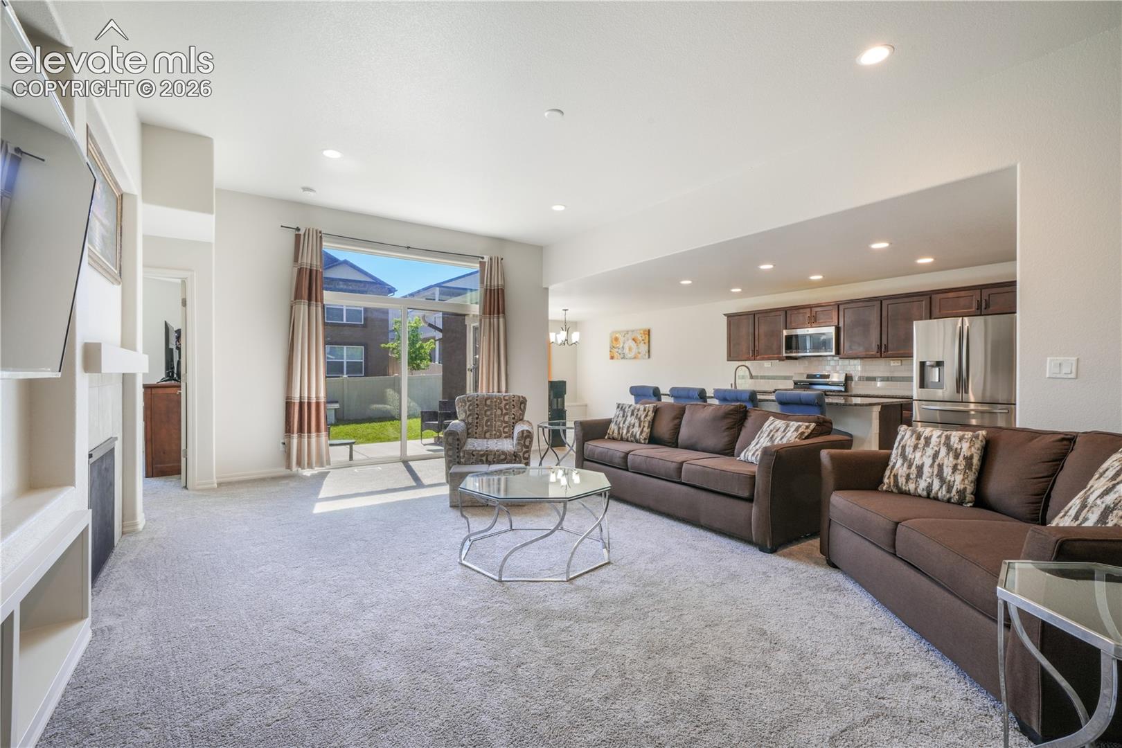 Livingroom with open concept, gas fireplace, large patio sliding doors and new carpet
