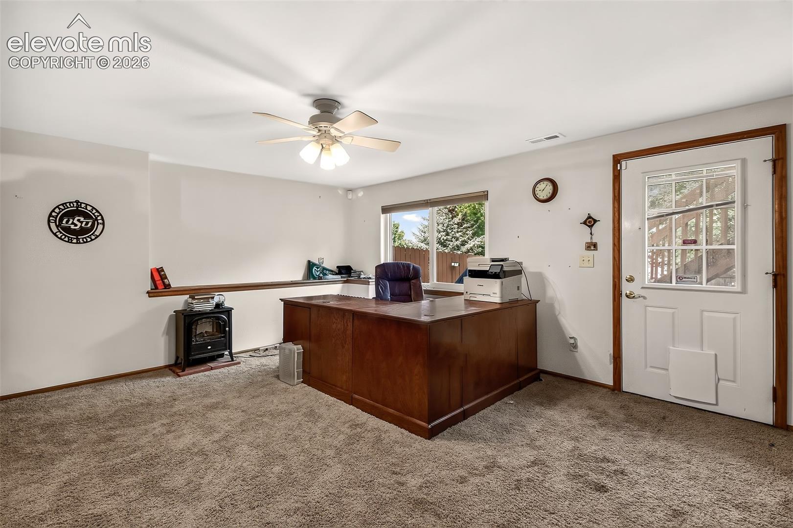 Bright Basement Area Used for  a Home Office. Note Electric Free-Standing Fireplace for Those Not-So- Warm Winter Days