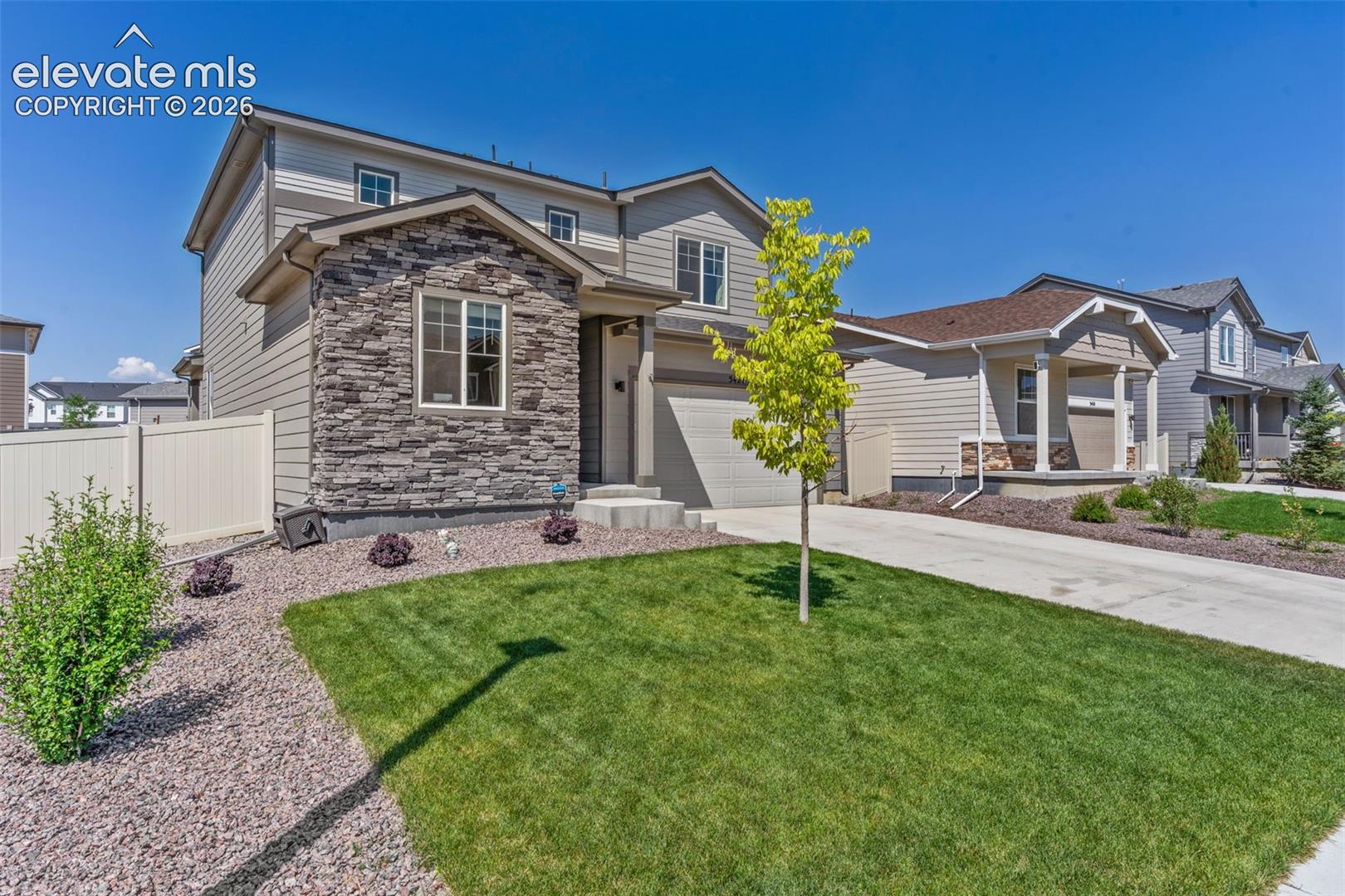 Two-story residence featuring a stone and siding exterior