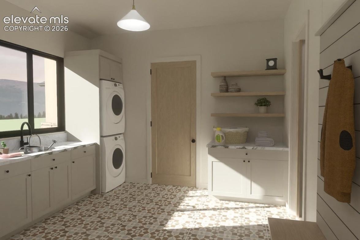 Patterned floor tile, stacked laundry appliances, white cabinetry with countertops, dark framed window, and natural wood floating shelves