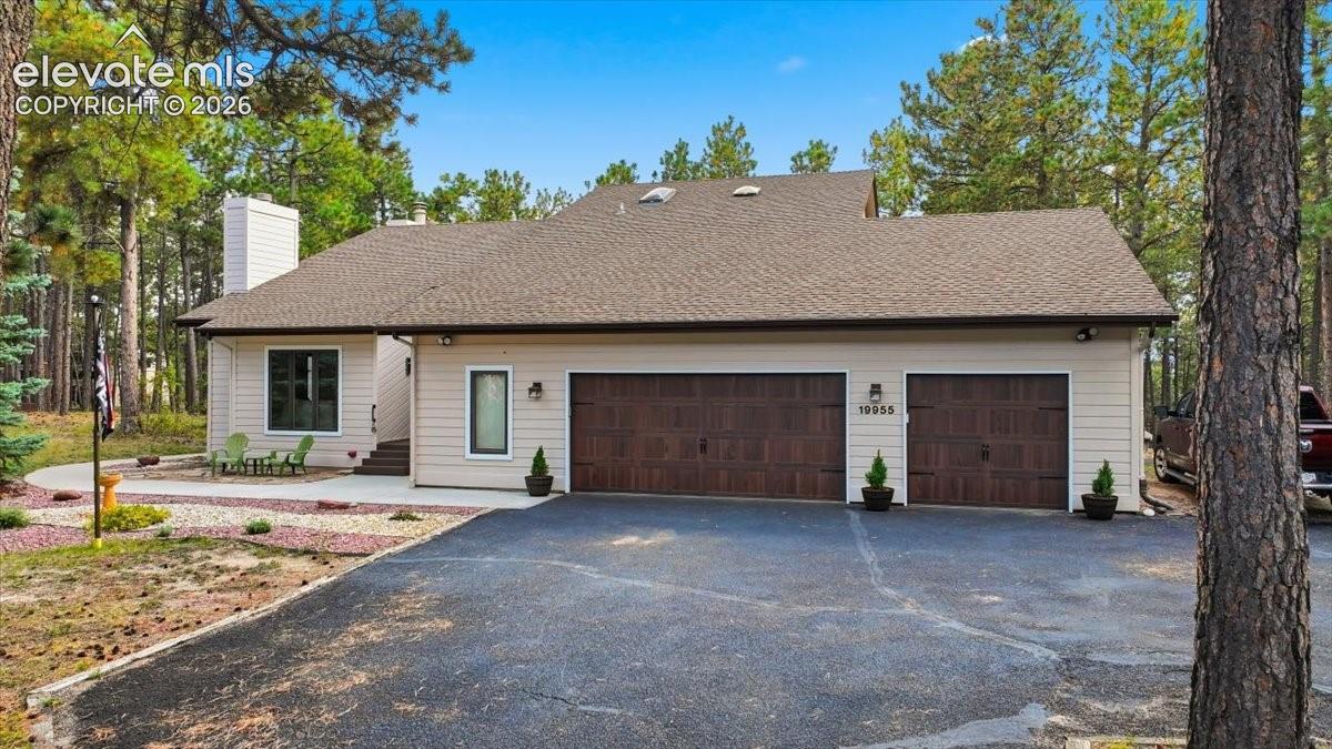 Siding exterior with a neutral color palette, wood-finish garage doors, and a double car garage