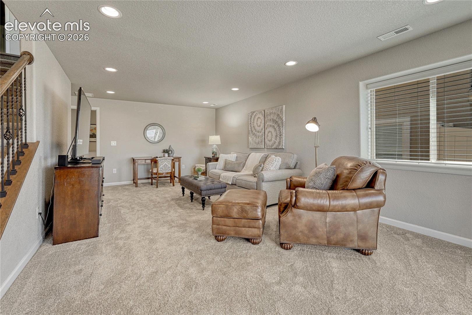 The finished basement expands the home's living space with comfortable carpeting, recessed lighting, and a versatile layout ready for recreation or relaxation.