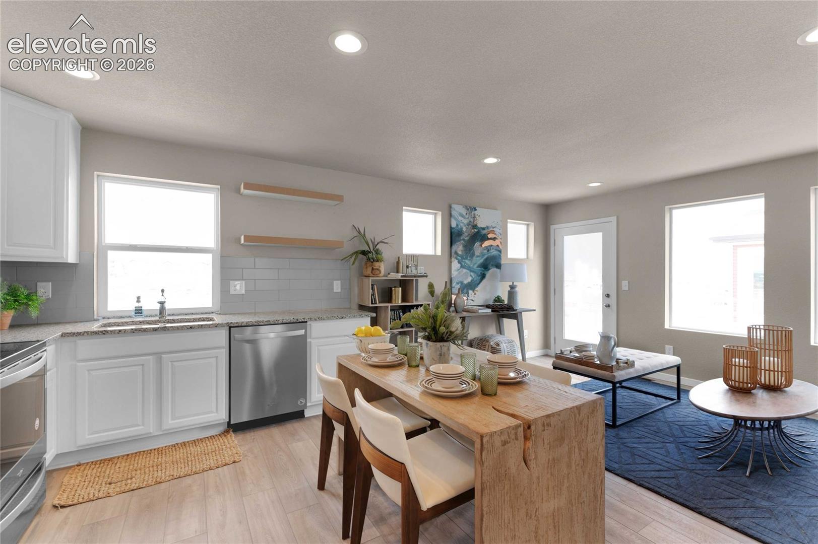 Recessed lighting, wood-finish flooring, white cabinetry, integrated stainless steel dishwasher, and a glass-paned exterior door
*photos of a model home*