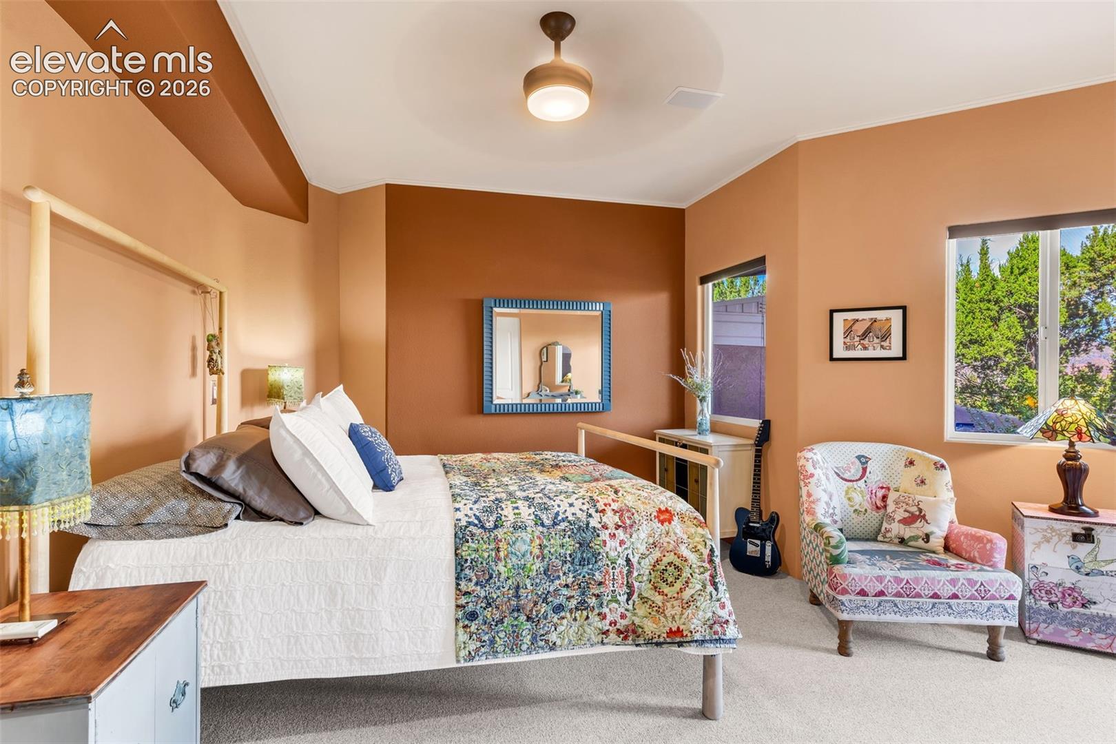 High ceilings with a central drum-style pendant light, dual-tone accent walls, and carpeted flooring