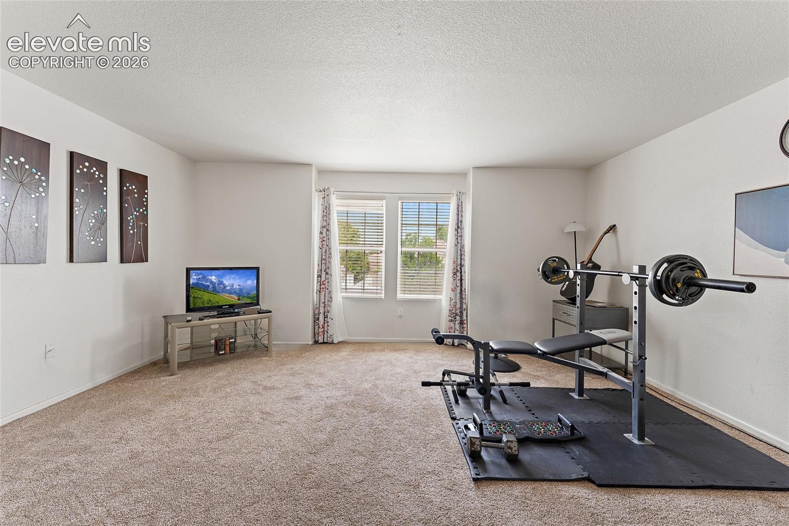 Neutral-toned wall-to-wall carpeting, dual-pane windows, and a textured ceiling