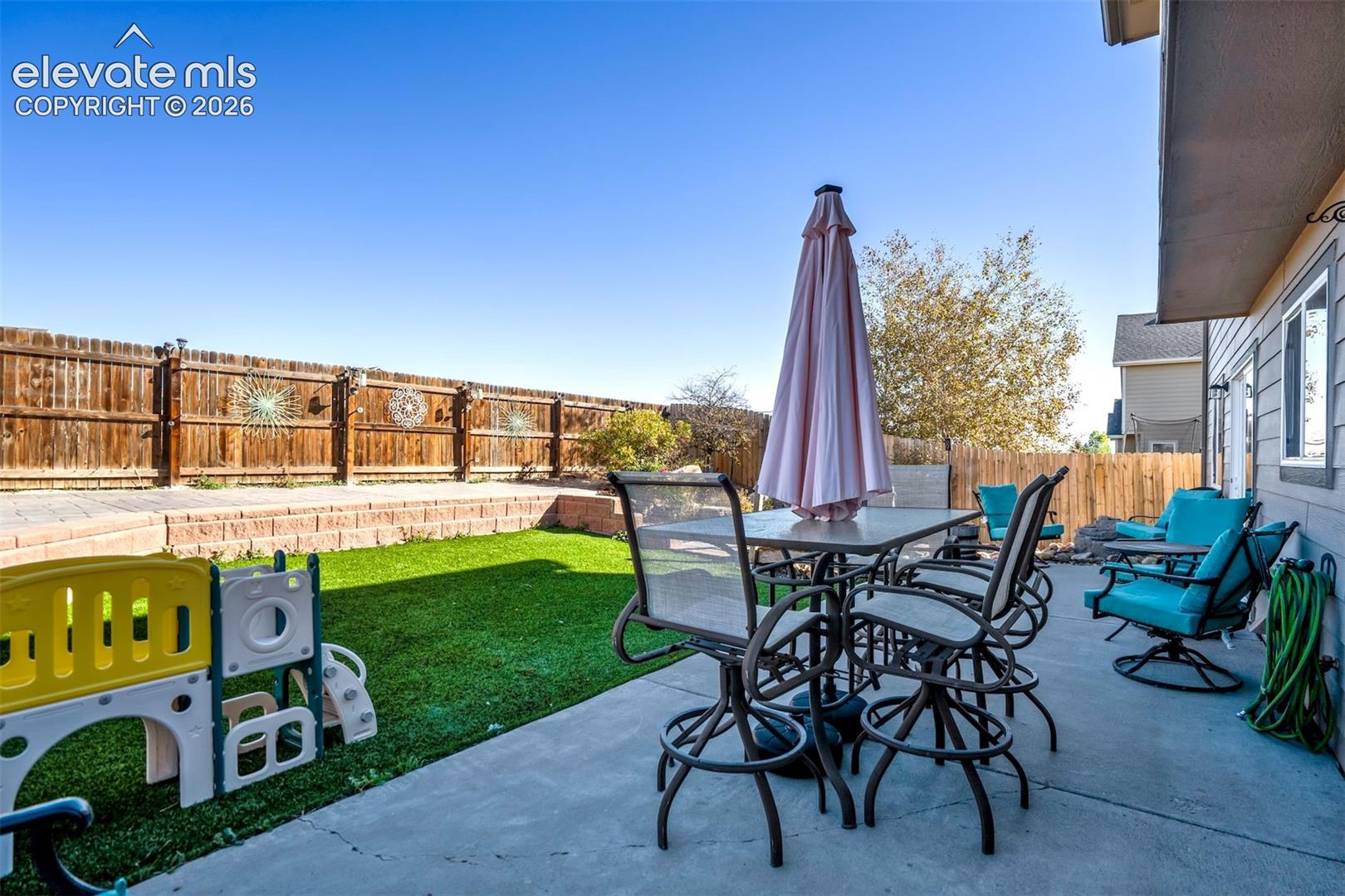 Extended concrete patio with low maintenance turf. 
