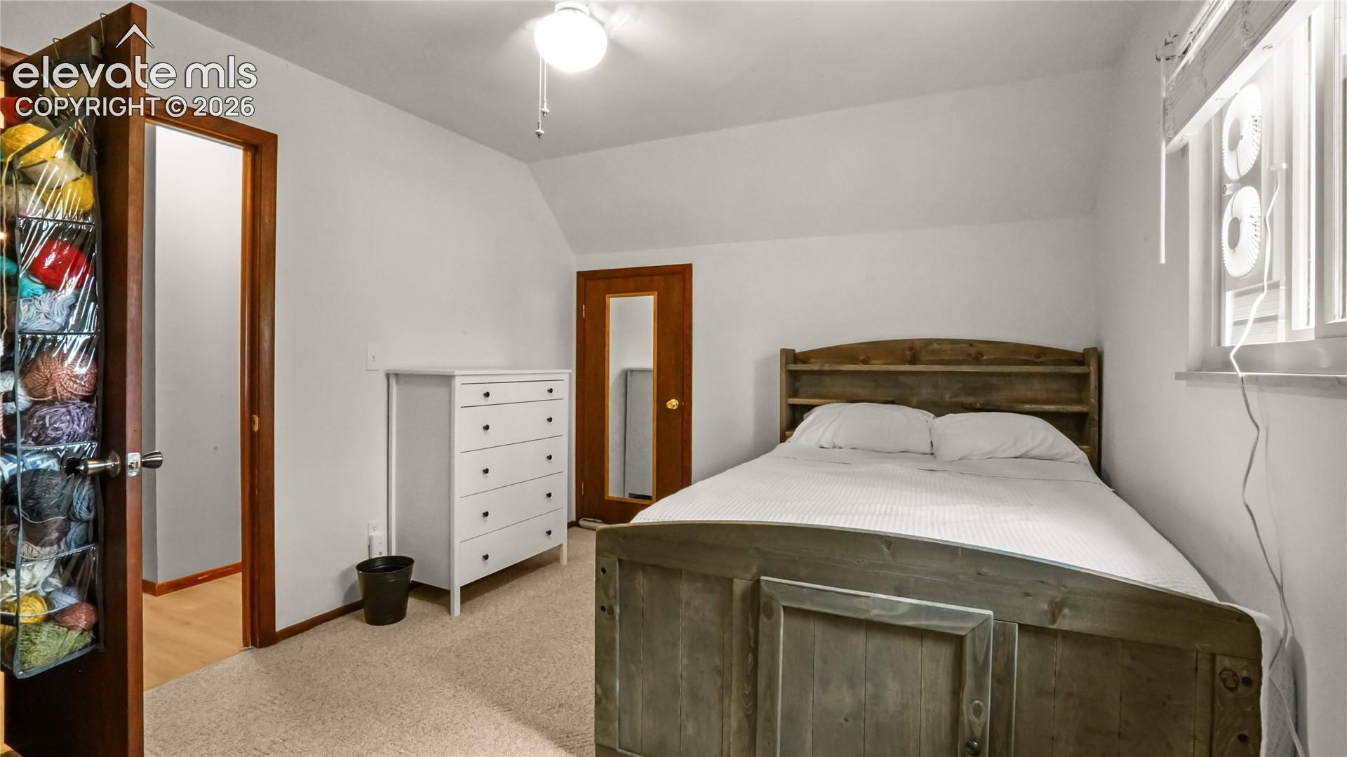 2nd upstairs bedroom, with white walls, sloped ceiling, and a window with blinds. Carpet.