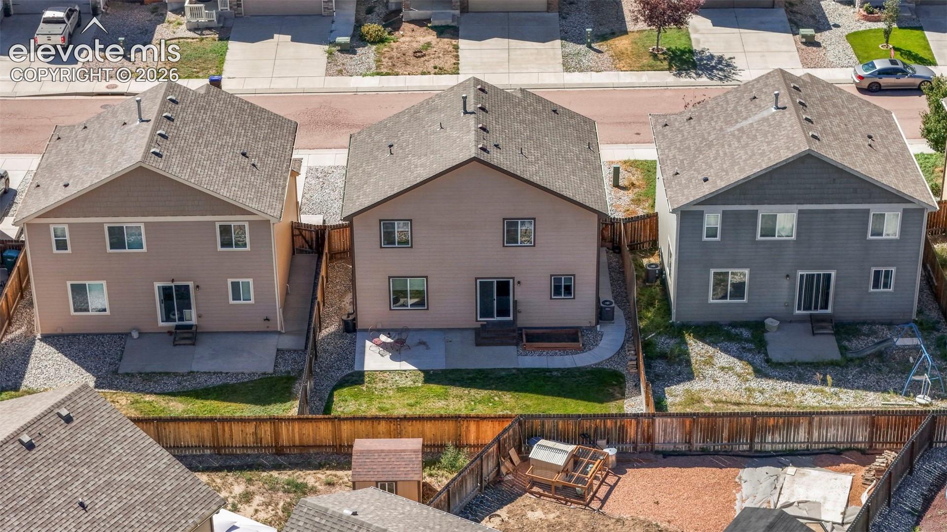 Rear exterior with private fencing, ground-level patio, and sliding glass door