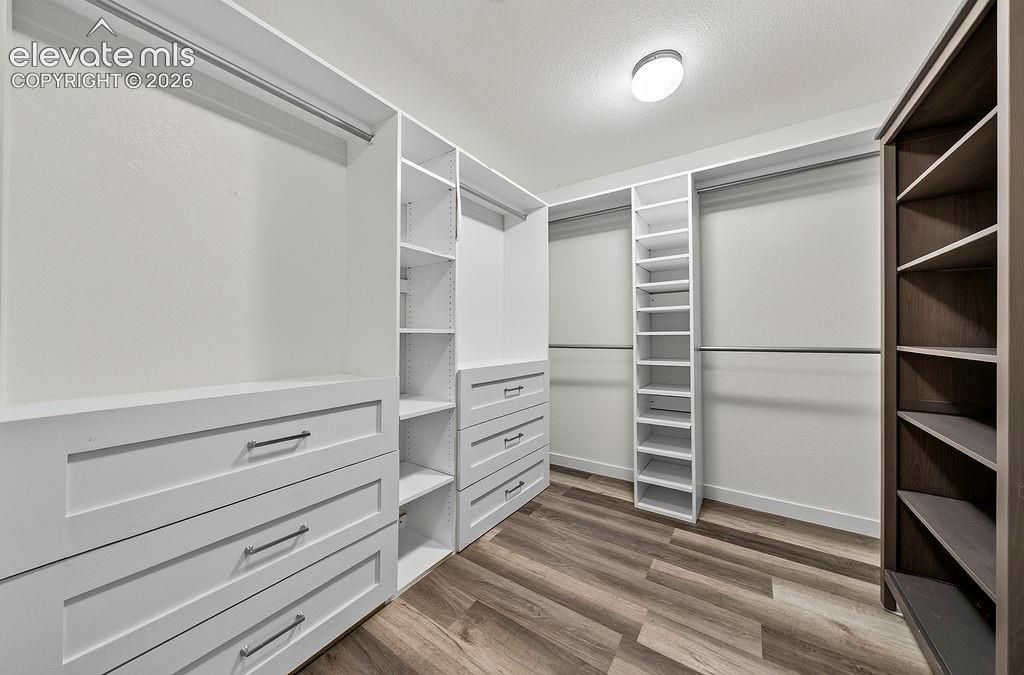 Custom closet organization system featuring built-in drawers with modern pulls, shelving, and hanging rods
