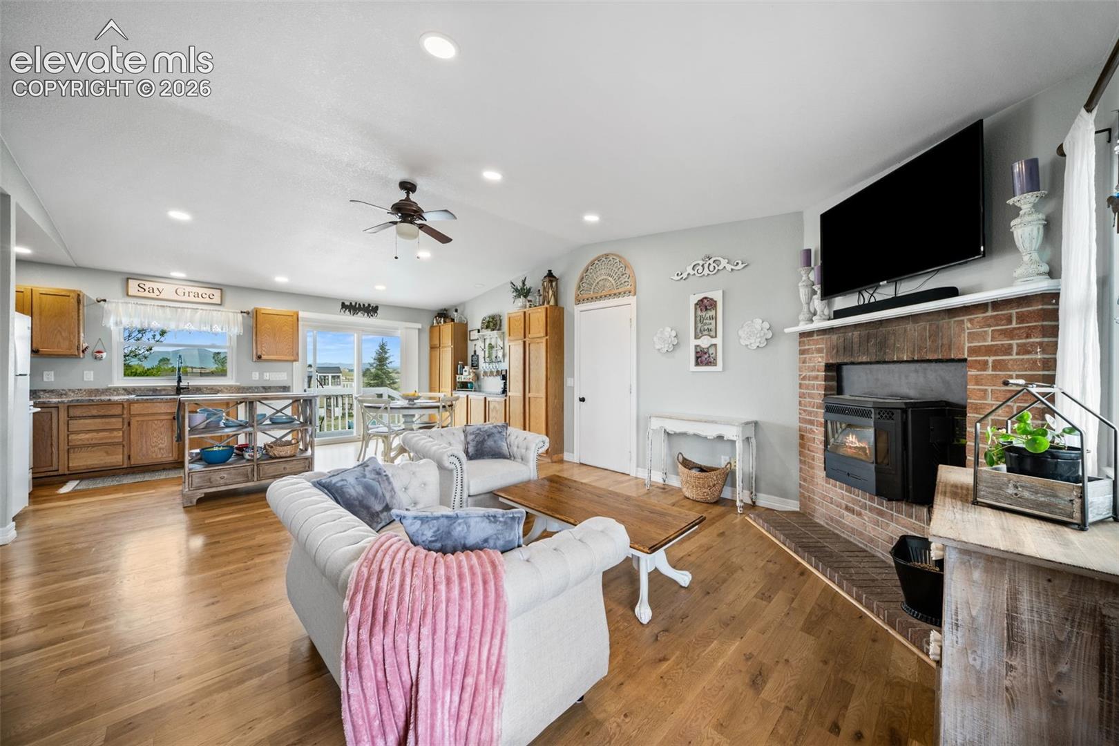 Open-concept living area featuring wood-finish flooring, recessed lighting, and a ceiling fan
