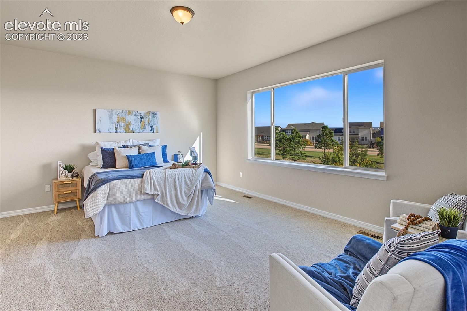 Room featuring neutral wall tones, wall-to-wall carpeting, a large picture window, and a flush-mount ceiling light fixture