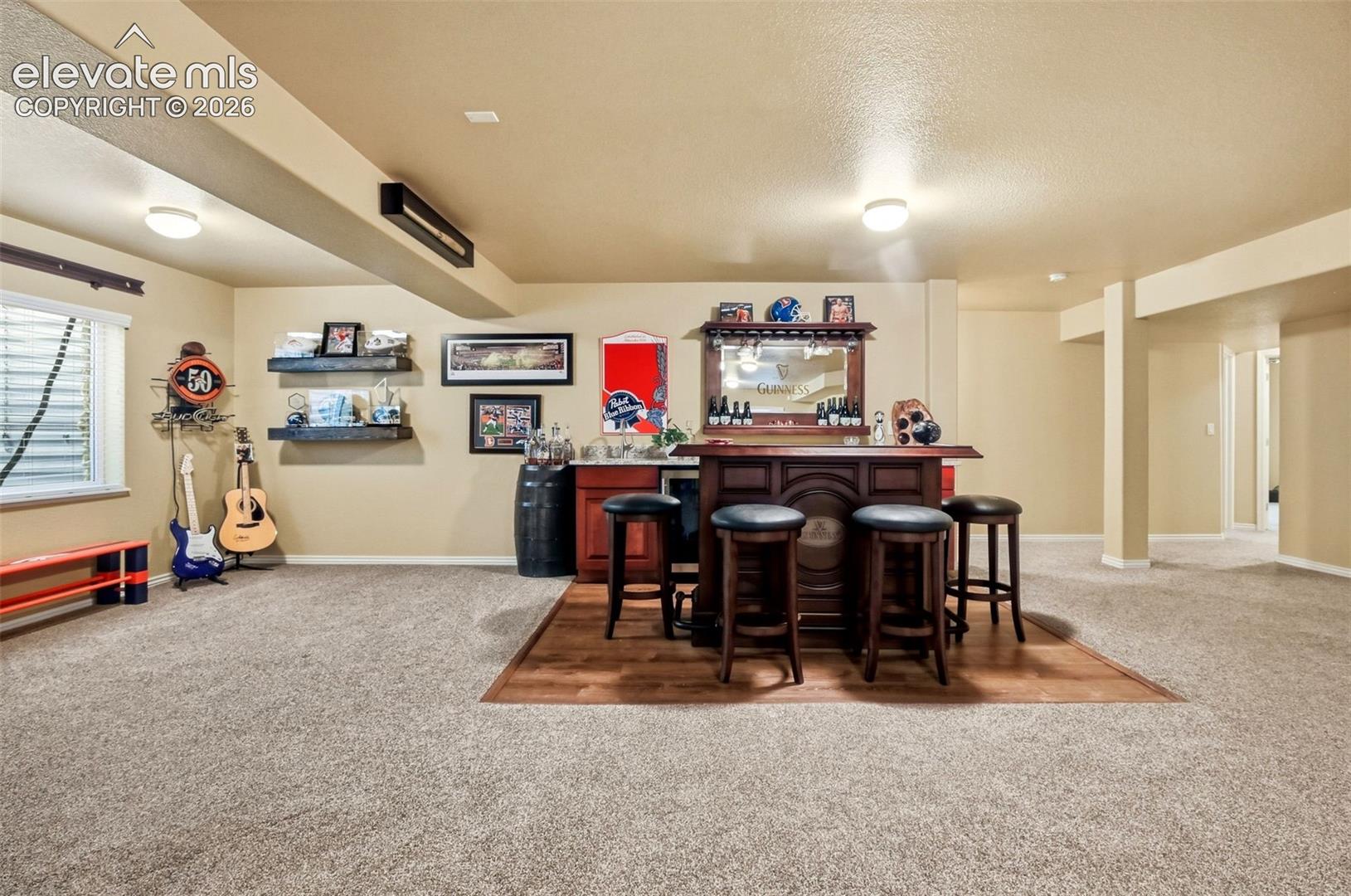 Built in wet bar, stainless steel sink and beverage cooler/mini fridge. Here the Guinness themed bar, mirror and stools stay with the property giving this space a ready-made hang out vibe.