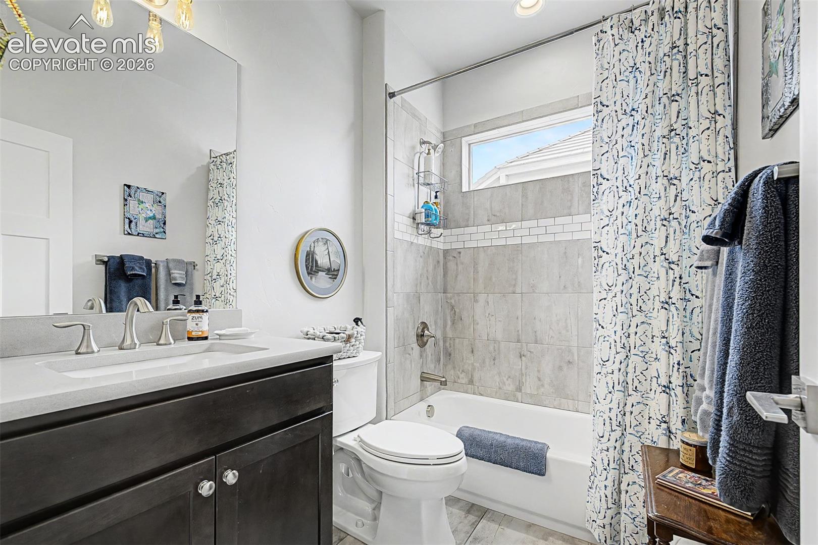 Beautiful tiling and quartz countertop make for a beautiful guest bathroom.