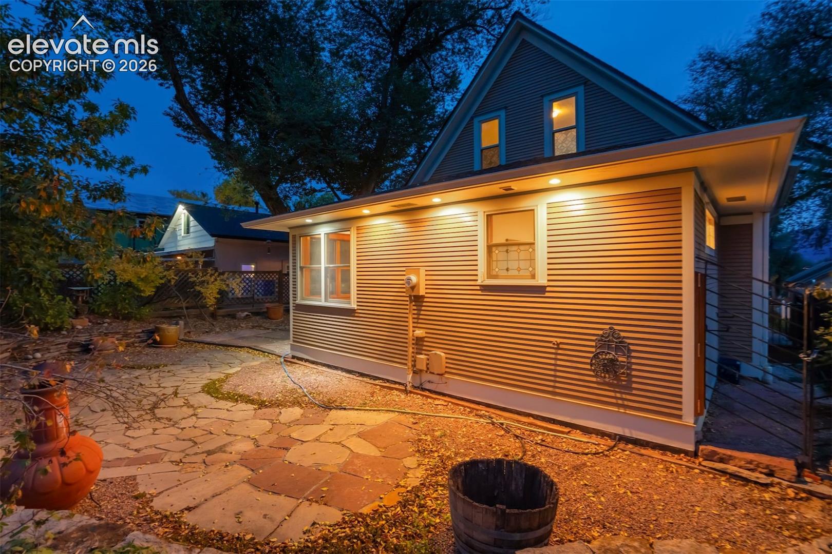 Flagstone patio with exterior lighting and ribbed siding