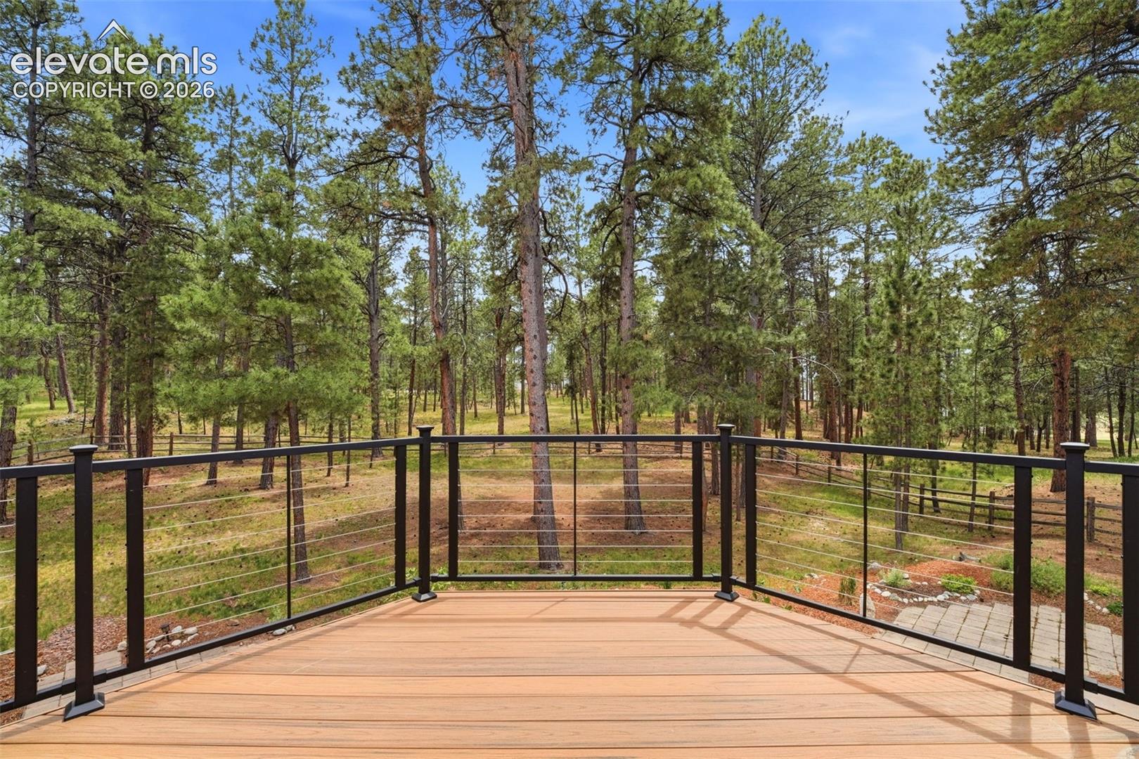 Spacious outdoor deck with wood-finish flooring and black metal cable railings