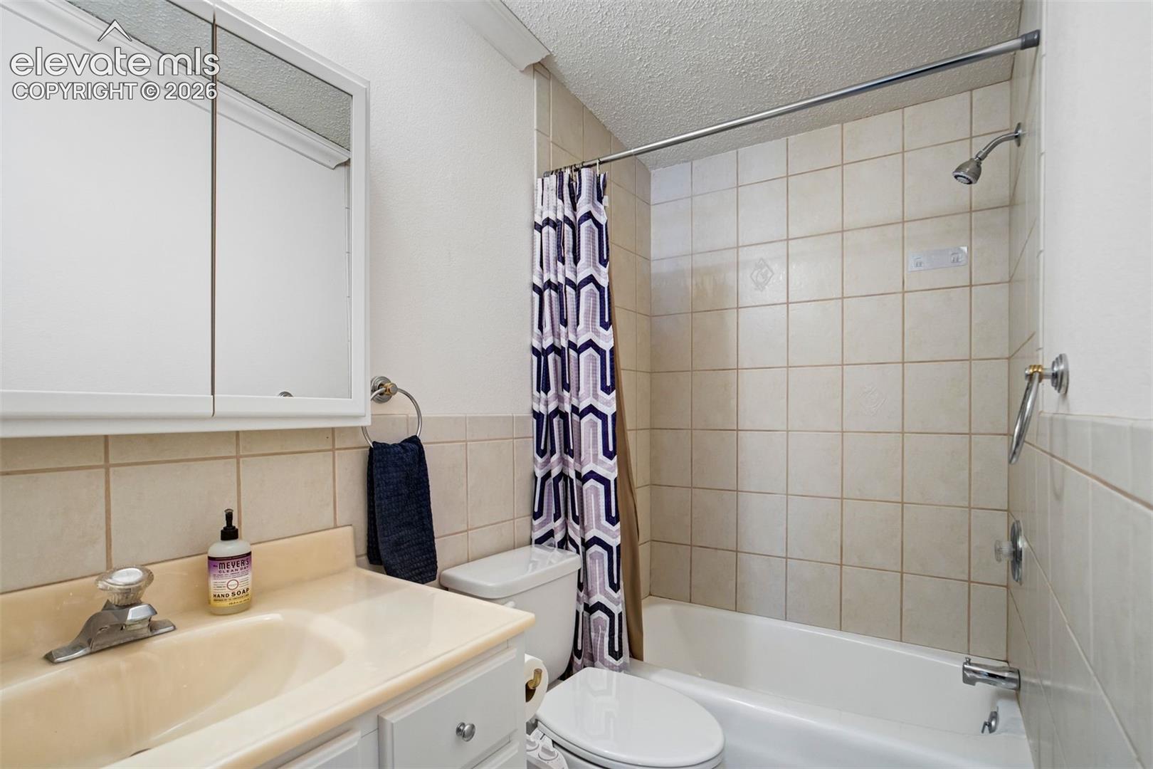 Functional full bath with tub/shower combination and extended tile detail.
