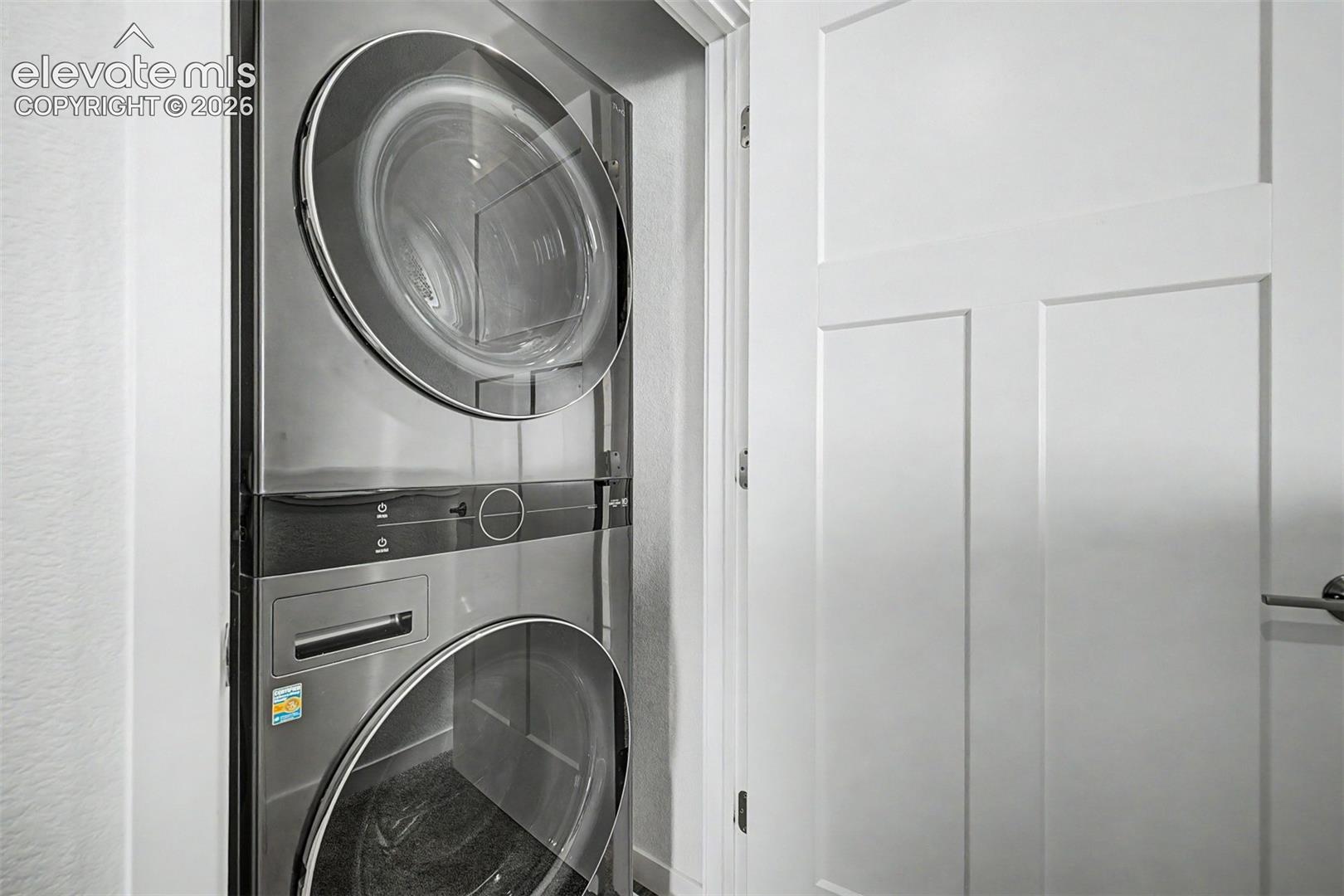 Tucked neatly behind a closet door, the stacked front-load washer and dryer are modern, sleek, and entirely out of sight when not in use — a practical detail executed with the same clean intentionality as the rest of the home.