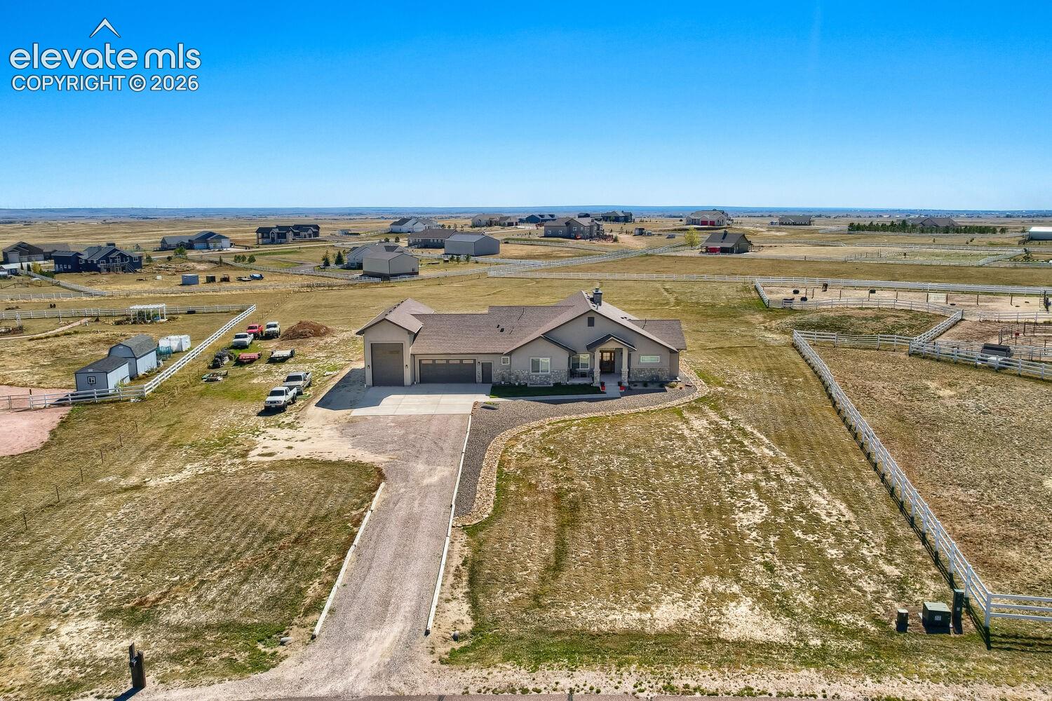 Ranch-style residence featuring a stone and stucco exterior, attached multi-car garage, and a paved driveway