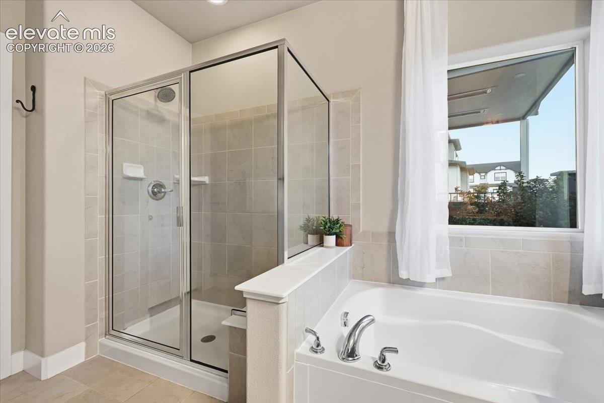 Walk-in shower with clear glass enclosure and light-toned tile surround