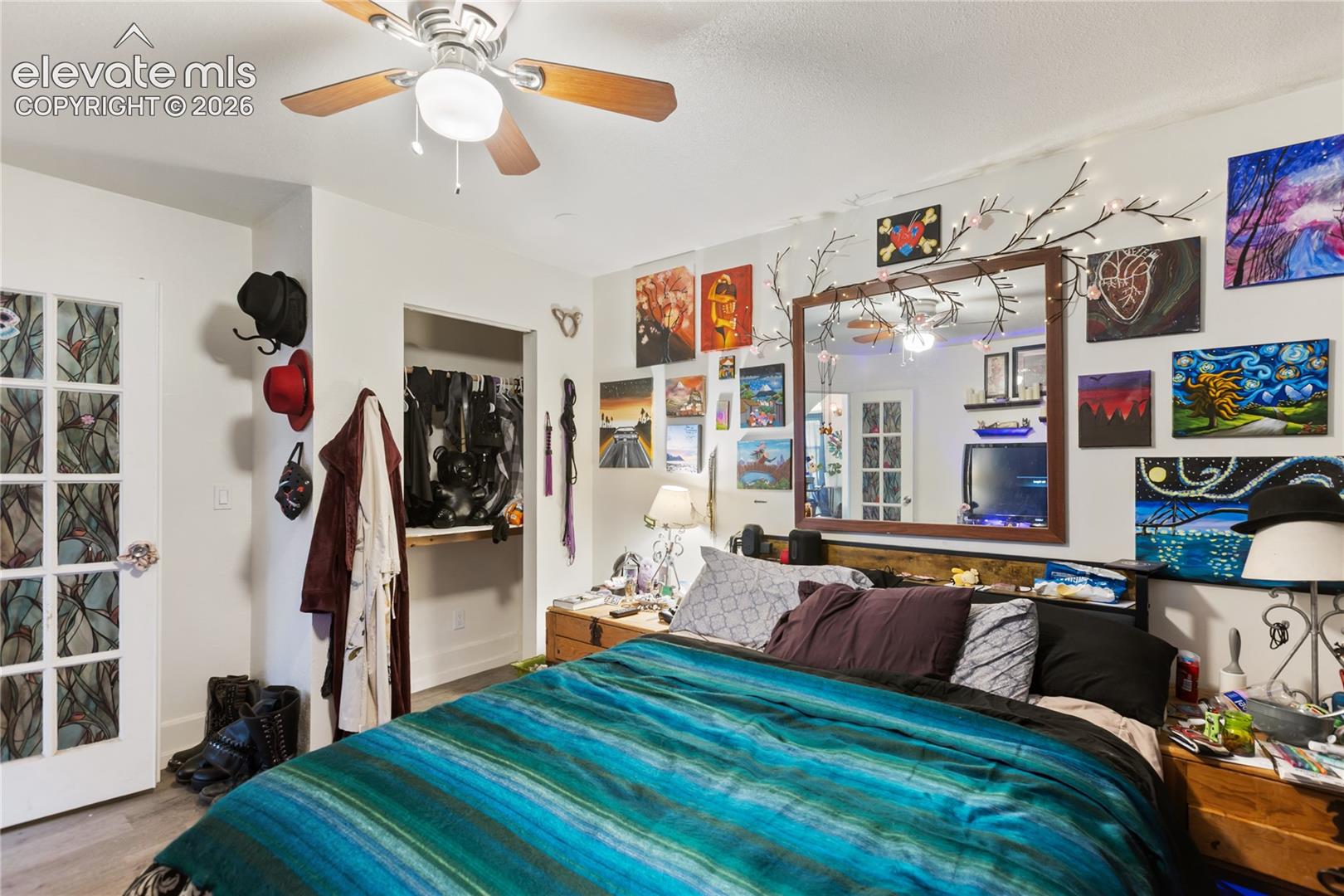 Bedroom featuring a multi-light ceiling fan, glass-paned door, and recessed closet space