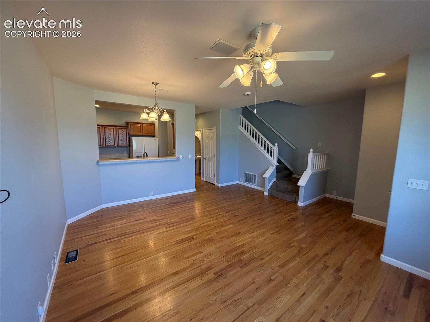 Hardwood flooring throughout, recessed lighting, and a ceiling fan with integrated lighting