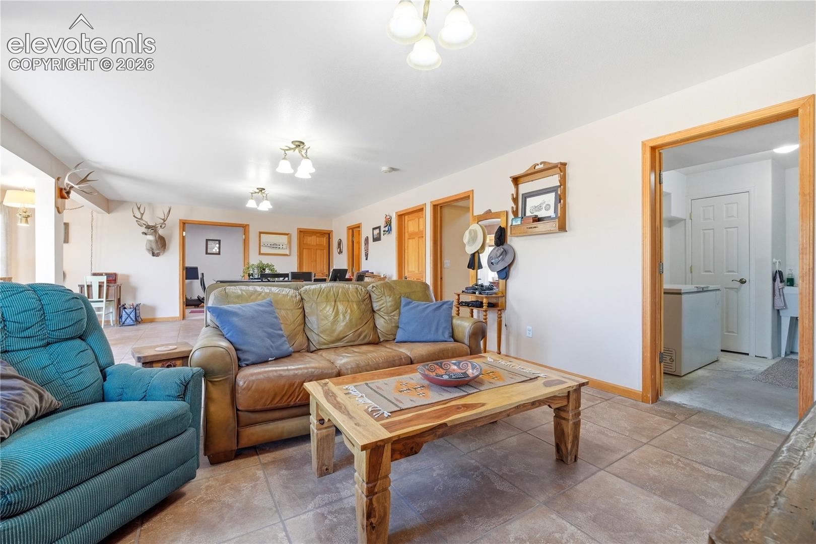 Spacious room featuring tile flooring, light-toned walls, recessed lighting, and wood-trimmed doorways
