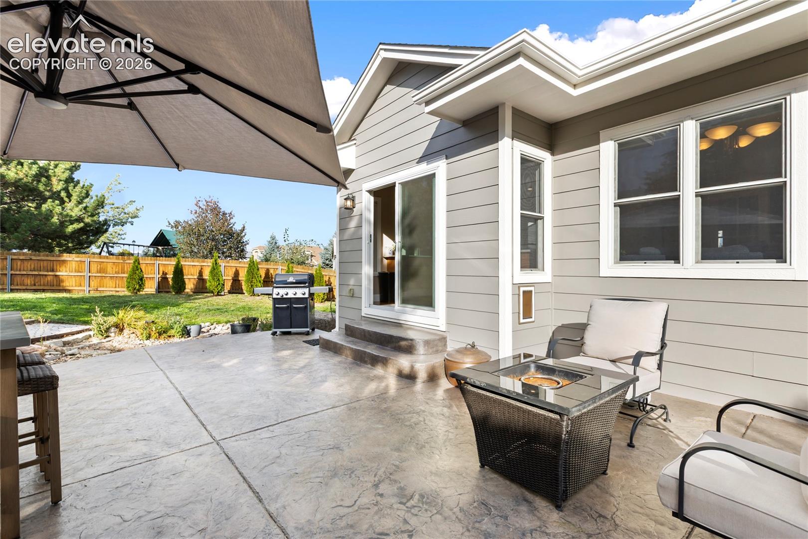 Expansive stamped concrete patio with direct access to the backyard and a sliding glass door