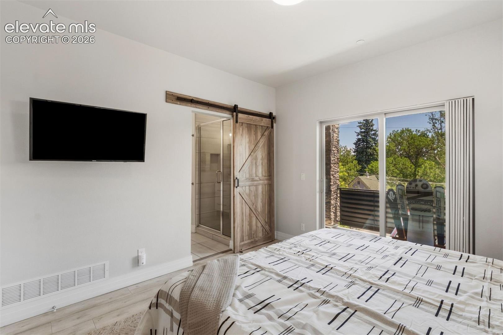 Primary bedroom with ensuite bathroom, walk-in closet, and private deck with roof top access