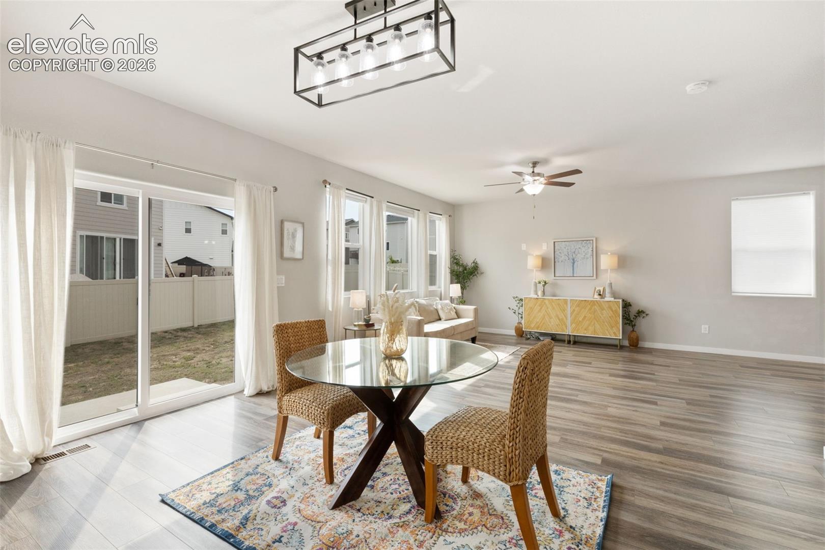 Open-concept living space with wood-finish flooring and ample natural light from multiple windows