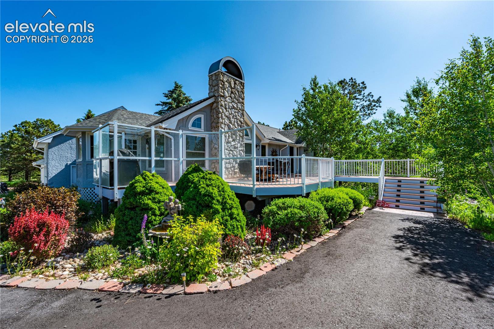 Beautifully landscaped front elevation with mature trees and inviting curb appeal.  