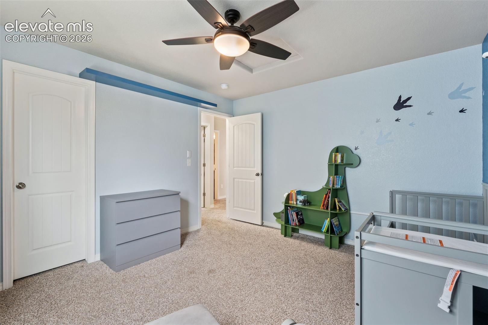 Carpeted flooring, ceiling fan with integrated lighting, and multiple paneled doors