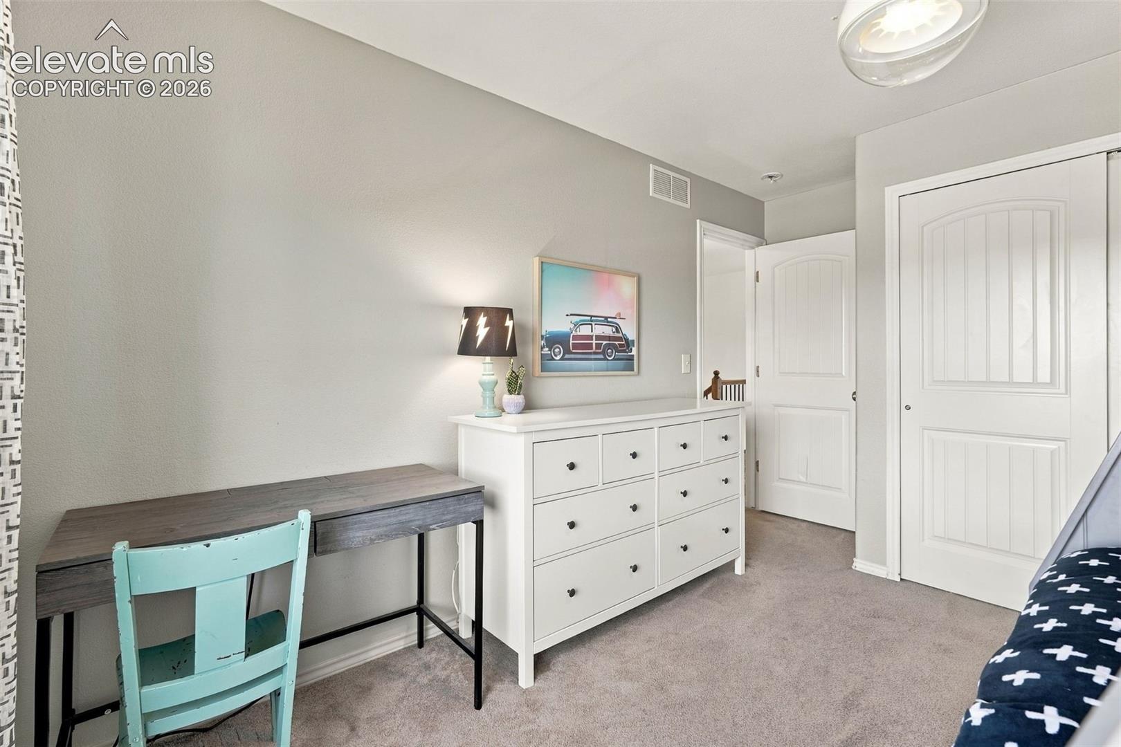 Neutral-toned interior featuring wall-to-wall carpeting, multi-panel interior doors, and a flush-mount ceiling light fixture