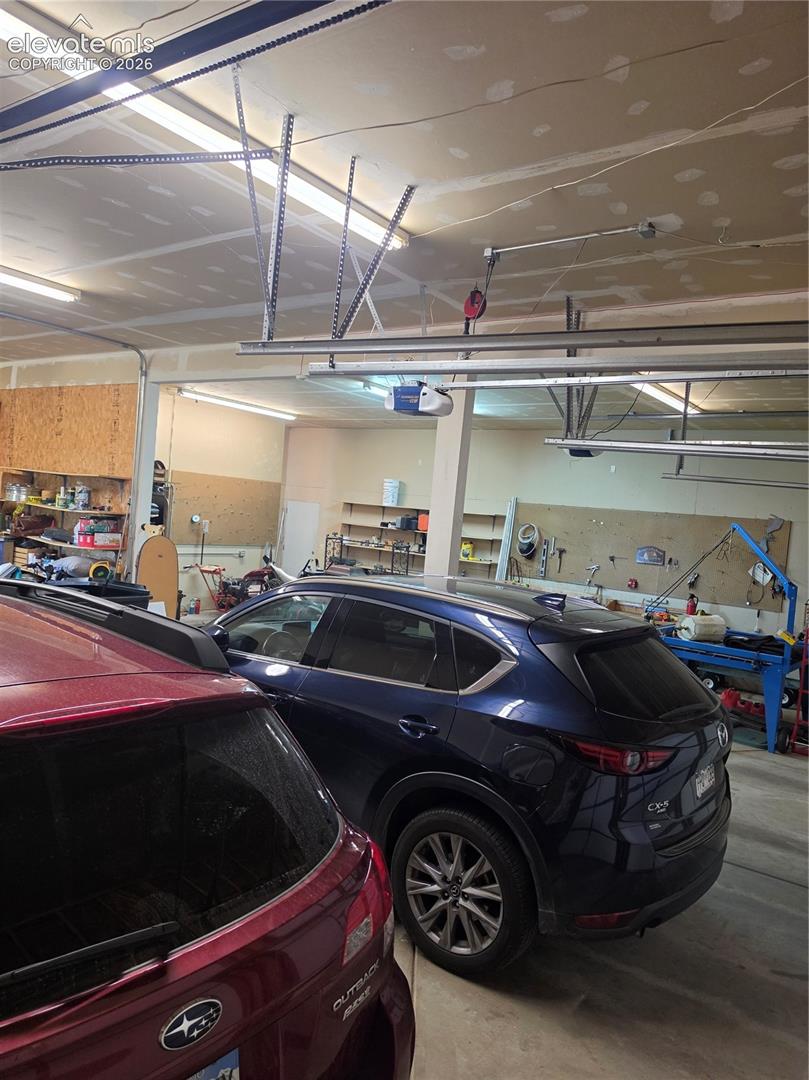 Garage featuring an automatic door opener and overhead fluorescent lighting
