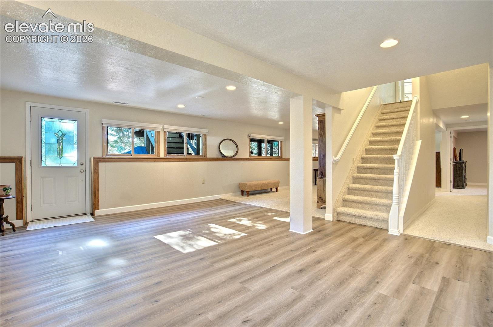 Luxury vinyl plank flooring defines a separate lower-level living area with space to gather, play or create.