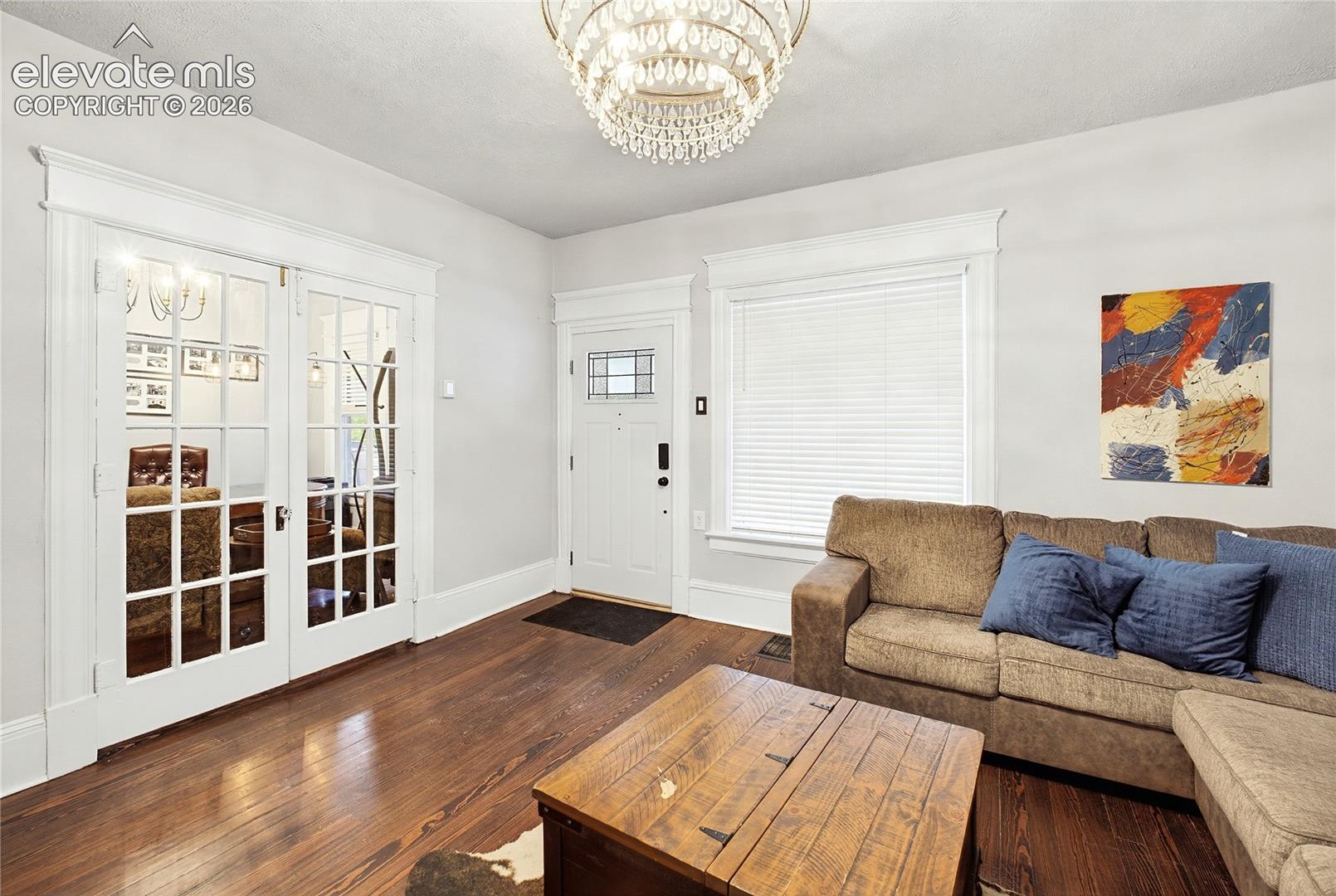Hardwood flooring, crystal chandelier, double French doors, front entry door with leaded glass, white trim