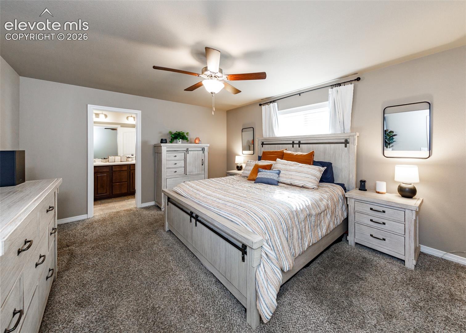 Neutral-toned bedroom featuring wall-to-wall carpeting and a central ceiling fan with integrated lighting