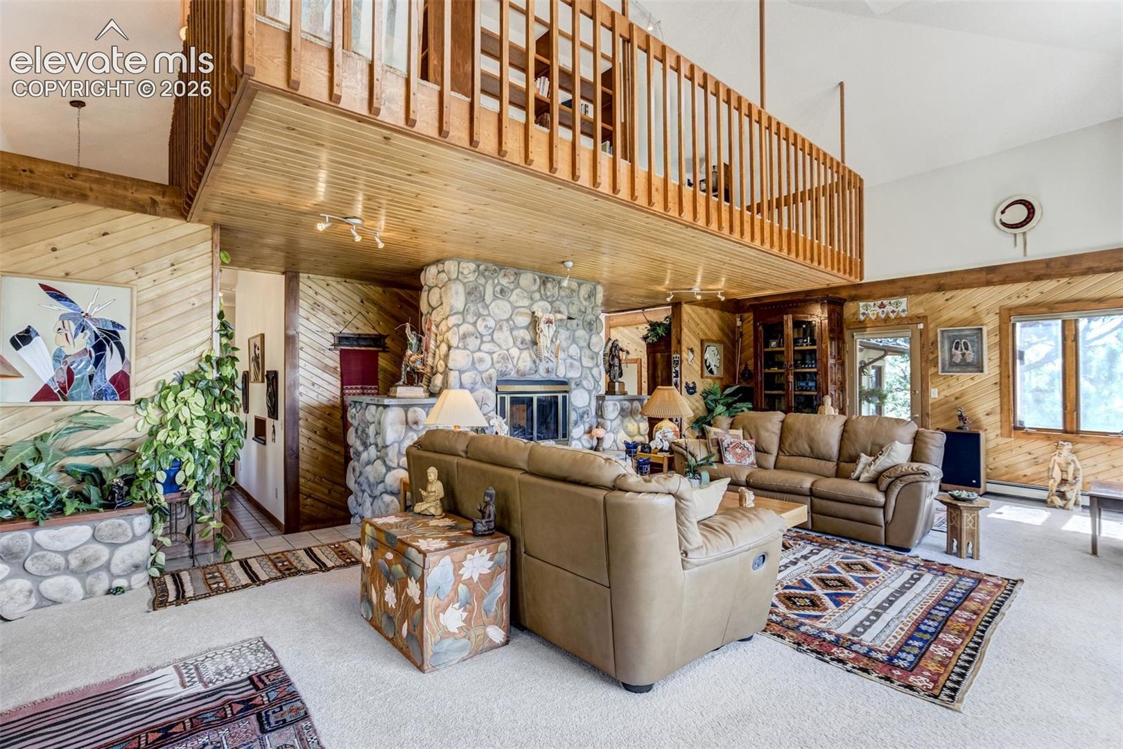 Living room boasts 20' high ceiling and a wall of windows where the views are. Stained pine wood accents on several walls