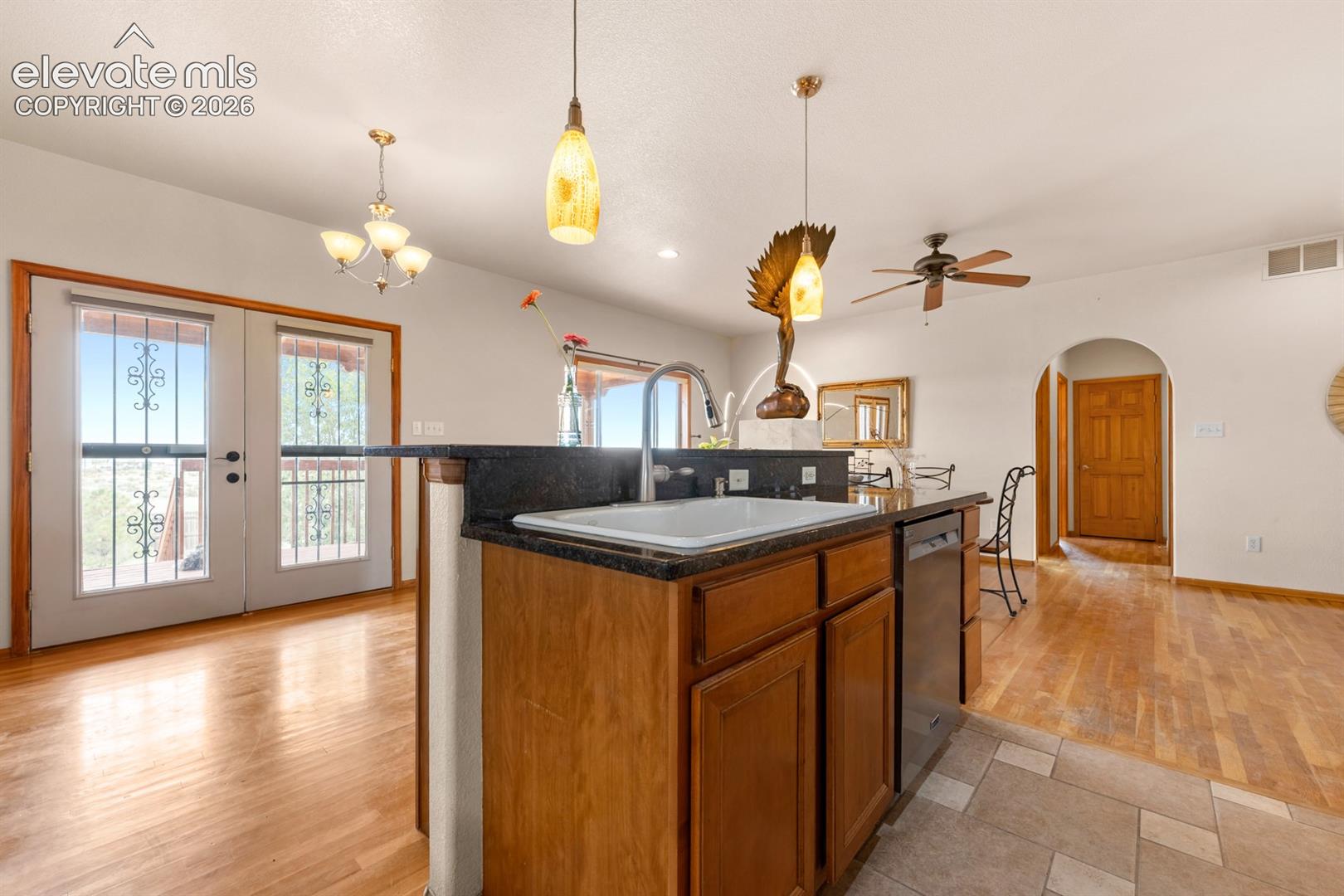 Tile and hardwoods on the main level.  Beautiful french doors extend to the lovely covered back deck.  Note the custom screen doors match the genre of the home.