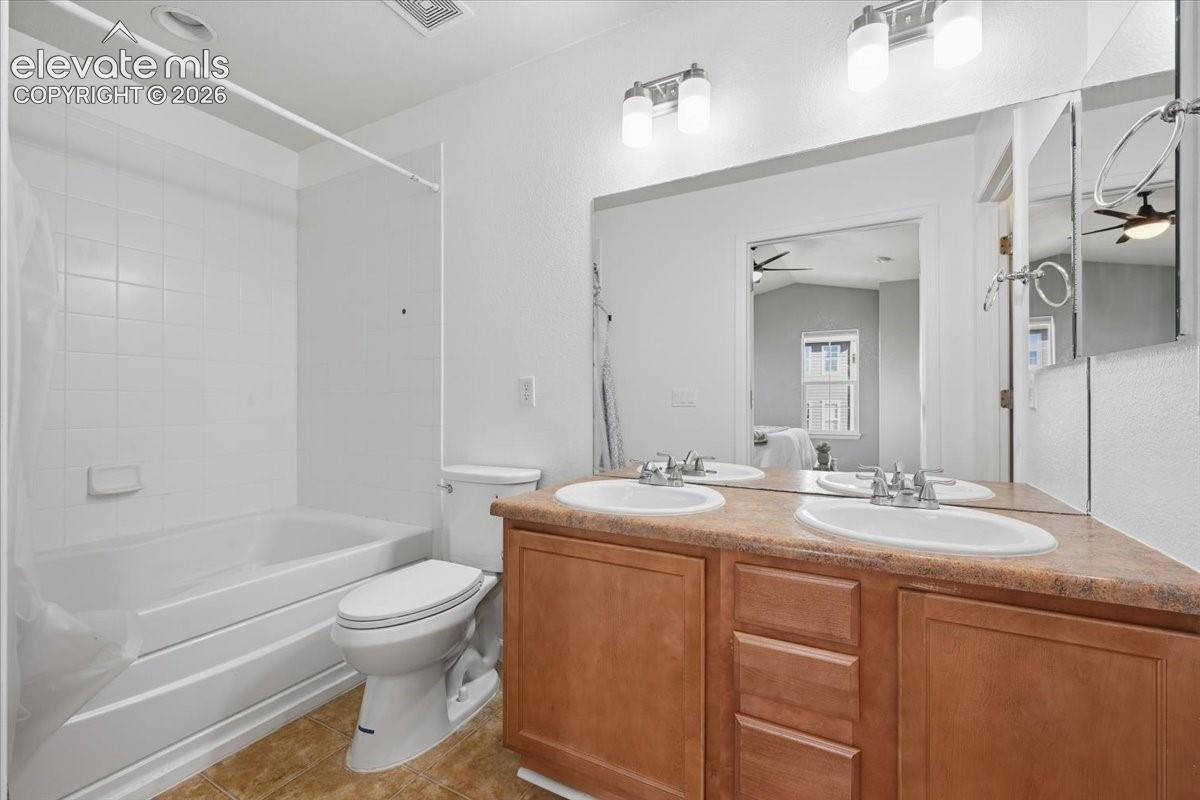 Dual vanity with integrated sinks, wood-finish cabinetry, and a full-width mirror