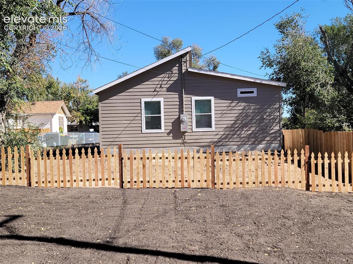 Exterior featuring horizontal siding, a shed roofline, and a wood picket fence enclosing a backyard area