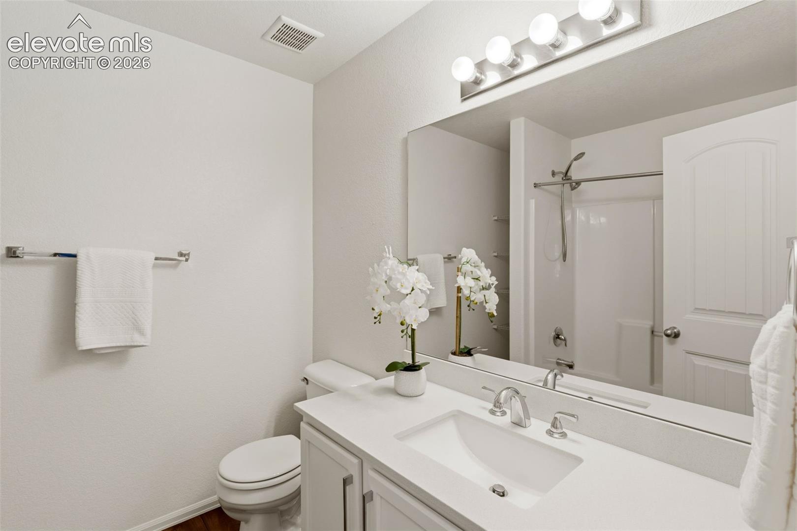 The upper-level secondary bathroom boasts clean finishes and plenty of counter space to streamline daily routines