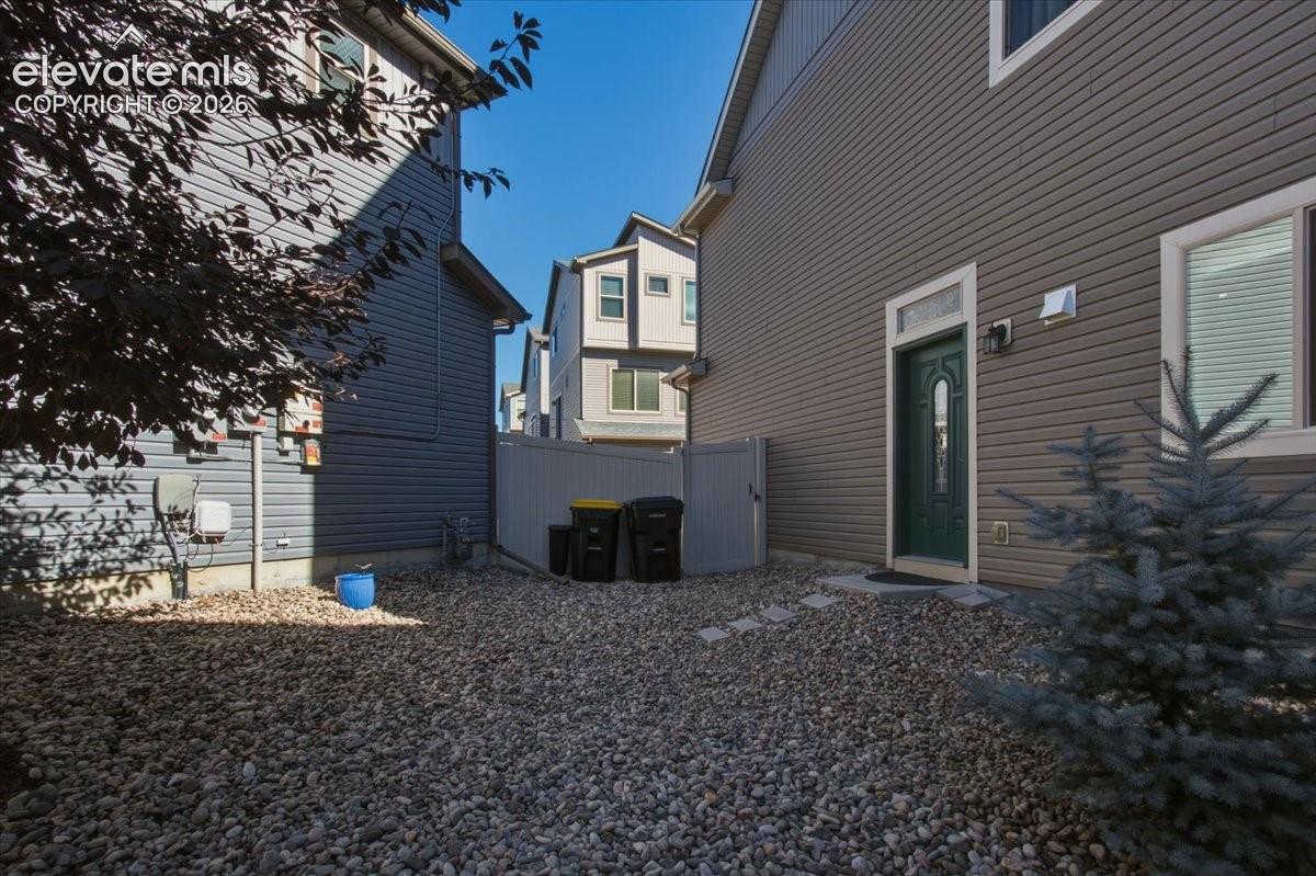 Gravel ground cover, exterior siding, and a fenced perimeter