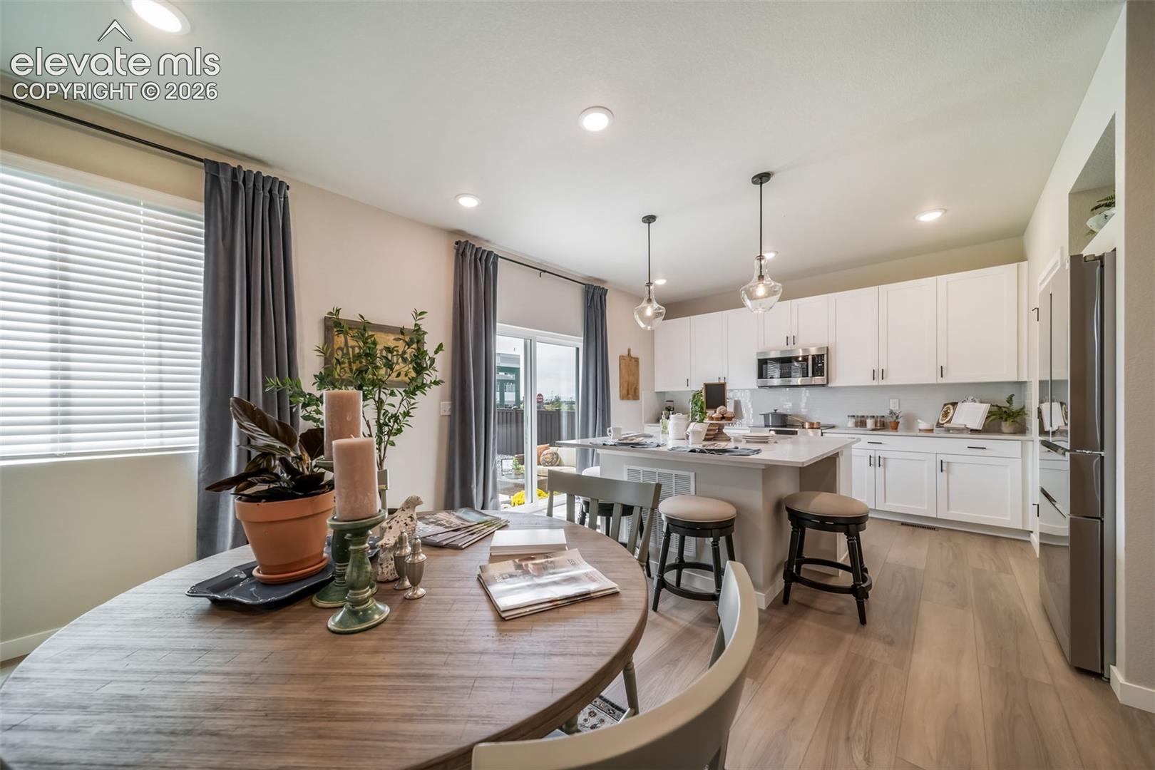 Open-concept kitchen and dining area featuring light wood-finish flooring
*Photos of a model home*