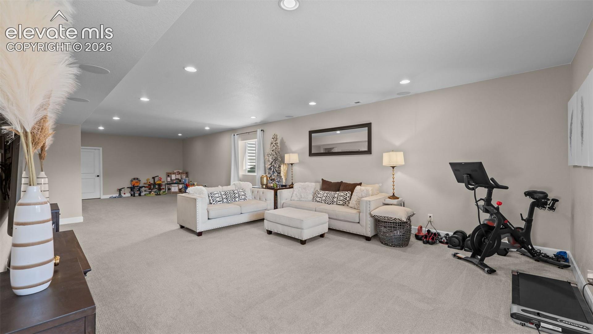 Expansive open-concept room featuring recessed lighting, light-toned carpeting, and neutral wall tones
