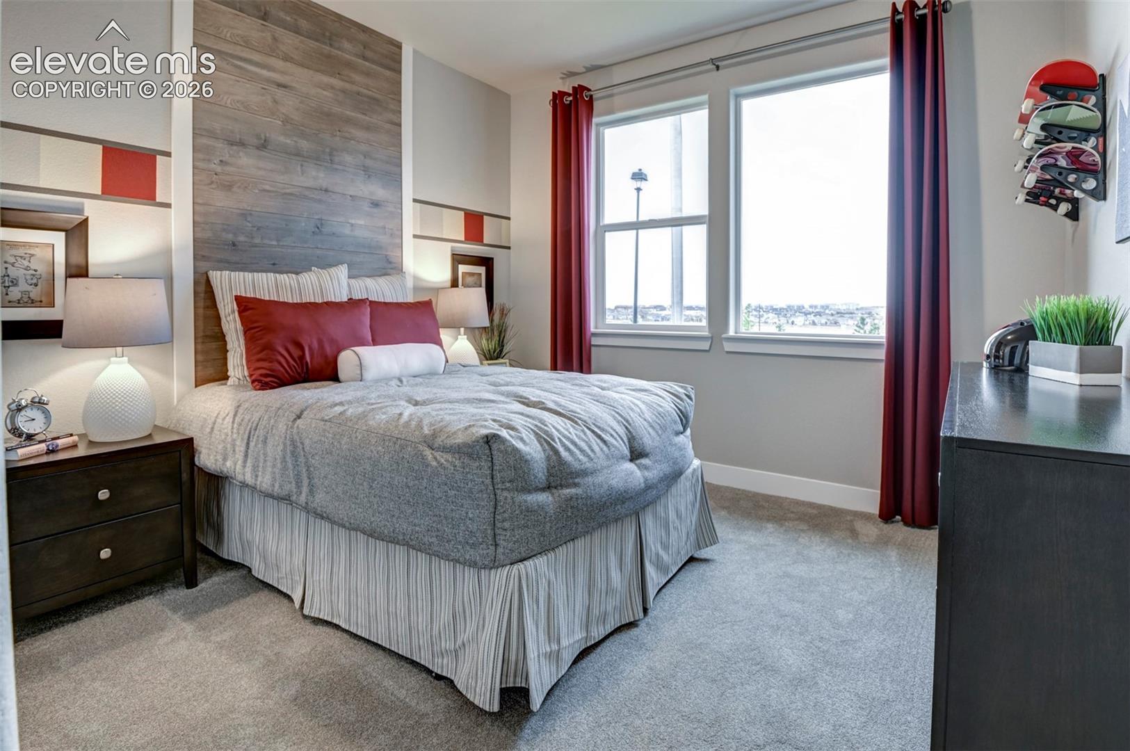 Recessed paneling with wood-finish accent wall, built-in shelving, two windows, and gray carpeting