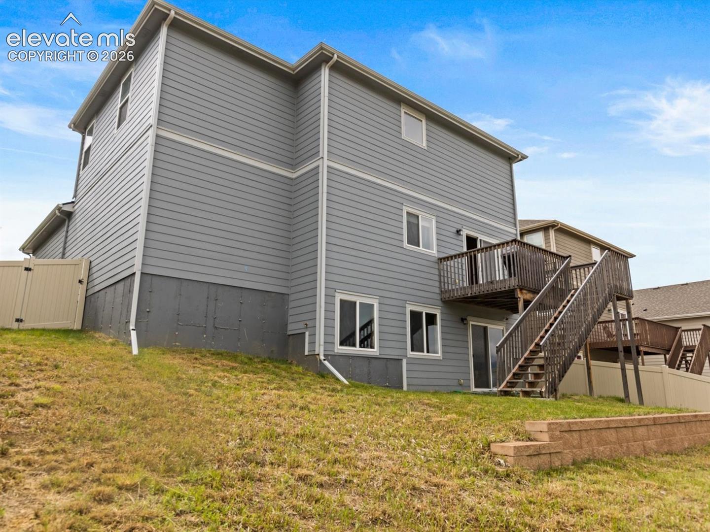 Gray siding exterior featuring a multi-level deck and staircase