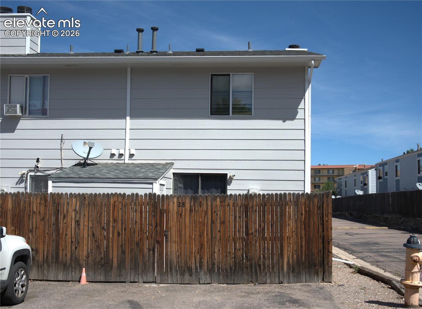 Back of home with patio and a wooden privacy fence