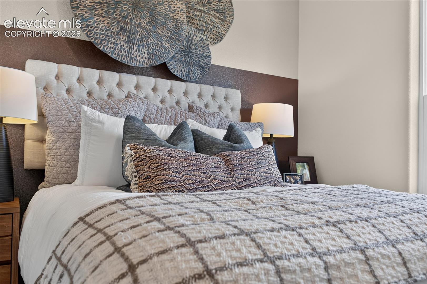 Tufted fabric headboard set against a two-tone painted wall