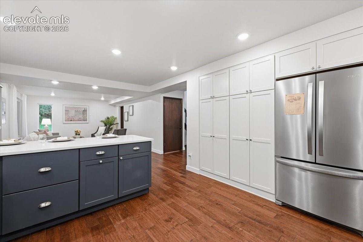 Contemporary kitchen featuring stainless steel French-door refrigerator, and warm wood flooring